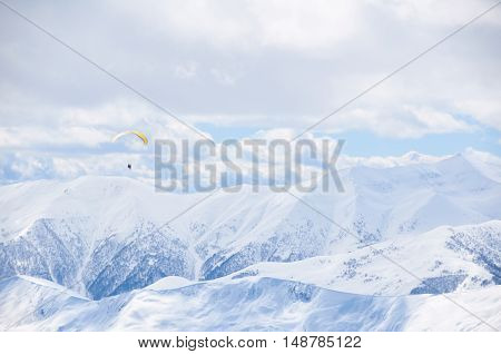 Beautiful winter peaks in mountains on ski resort in season of snowboard. High blue bright sky with white clouds in sunny day. Background for extreme sports.