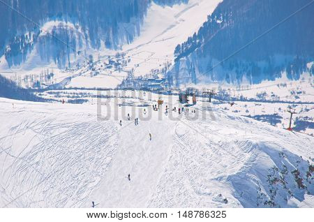 Bird view on peak of ski resort with ski riders and snowboarders. High point in mountains. Extreme active sport concept for healthy people. Place for holiday and weekend.