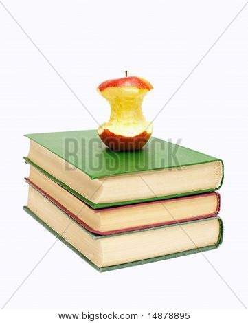 half eaten apple on a stack of books