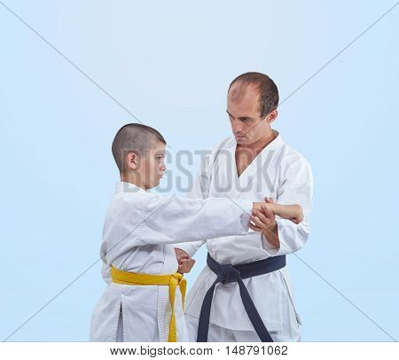 With black belt athlete is teaching athlete with a yellow belt