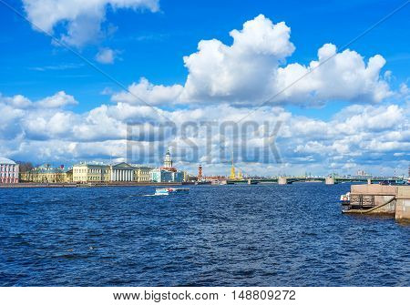 The view from Admiralty embankment on clouds over Bolshaya Neva river the landmarks of Vasilyevsky Island Palace Bridge and the tall golden spire of St Peter and Paul Cathedral Saint Petersburg Russia.