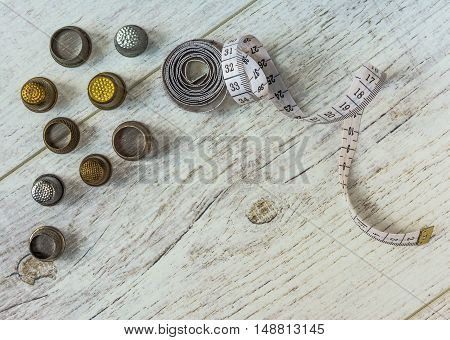 tapeline and old thimbles lie on the light board