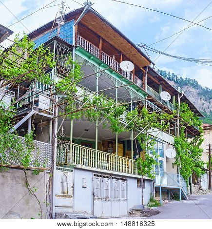 The typical house with wide terraces twisted grape vines and garden on the mountain in Borjomi Georgia.