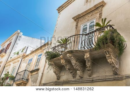 Balcony with baroque decorations in a house of Syracuse (Sicily)
