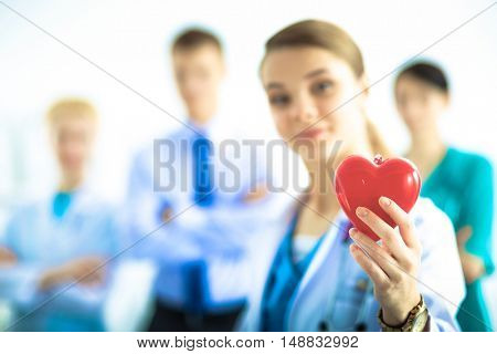 Female doctor with stethoscope holding heart .