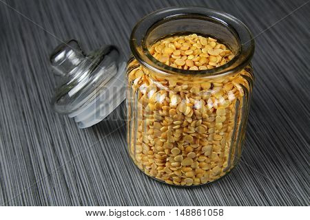 A jar of yellow lentils or Arhar daal in a jar on grey background selective focus.