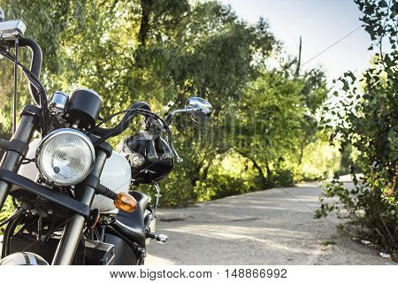 Motorcycle on the road with a helmet on the handlebars.