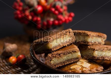Fresh Dutch filled spicy cookies with almonds on autumn colored and dark background
