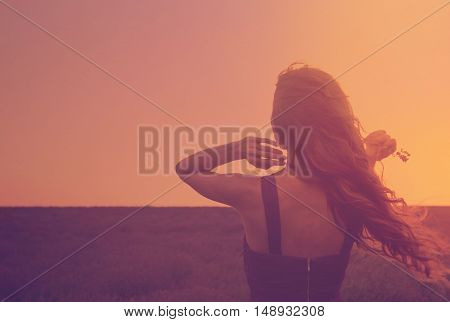 Silhouette Of A Young Woman With Long Hair Enjoying Beautiful Sunset In The Lavender Field. Back Vie