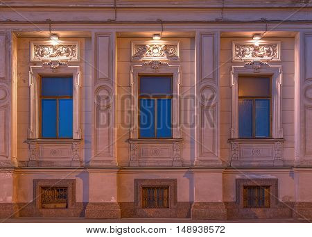 St. Petersburg Russia - August 4 2016: Three windows in a row on night illuminated facade of the Institute of Oriental Manuscripts front view