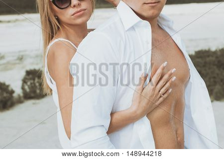 Sexy muscular naked man and female hands unbuckle his jeans.