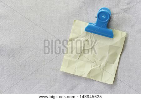 yellow of note paper placed on White fabric backgroundDesign ideas can be Entered your Message into the space as needed.