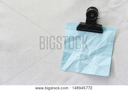 Blue of wrinkled note paper placed on White fabric backgroundDesign ideas can be Entered your Message into the space as needed.