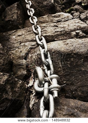Steel Bolt Anchor Eye In Hard Basalt Rock. End Of Steel Chain