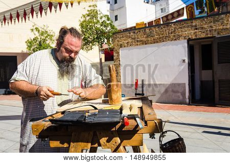 Badajoz Spain - September 23 2016: Medieval craftsman making arrows in market during celebration Almossassa in Badajoz Extremadura Spain