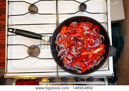Fresh vegetables, peppers and onions in a frying pan, cooking food at home soviet union kitchen