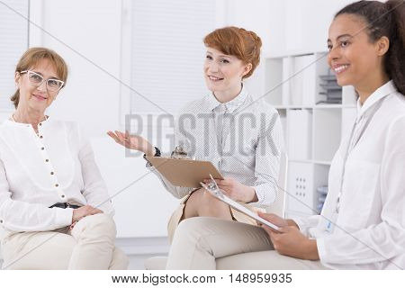 Three elegant woman sitting together and talking about the project
