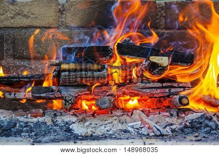 a flames on a Barbecue grill with lot of charcoal