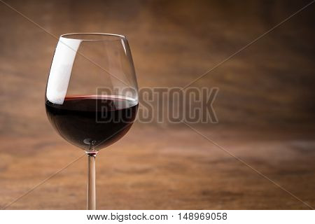 Glass of delicious mulled red wine for keeping warm in winter over an oak table background with copy space