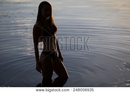 Side View Of Back Light Of A Woman Silhouette Breathing Deep Fresh Air At Warm Sunrise In Front Of S
