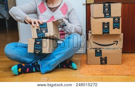 Paris, France - Jan 13, 2018: Woman Next To Stack Of Amazon Prime Packages Delivered To A Home Door 