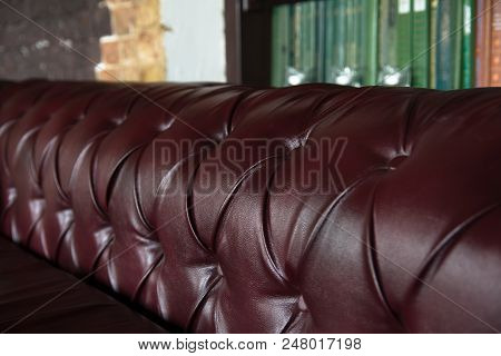 Background Close-up Burgundy Leather Sofa And Bookshelf