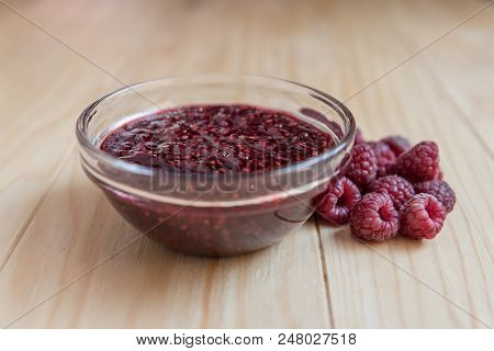 Homemade Raspberry Jam In A Glass Bowl With Fresh Ripe Organic Raspberries
 On A Wooden Table