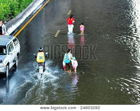 PHATHUMTRANI, THAILAND - 21 oktober: familie lopen met kinderen in de hoofdweg tijdens de ergste overstromingen