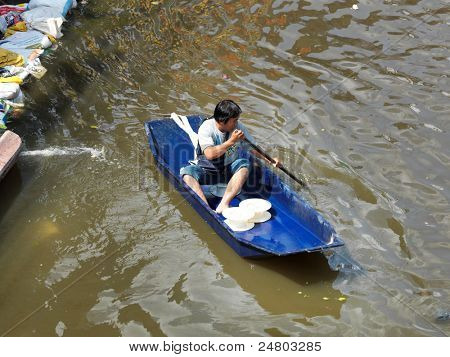 PHATHUMTRANI, THAILAND - 21 oktober: Man gebruikt boot als een transport door water tijdens het ergste