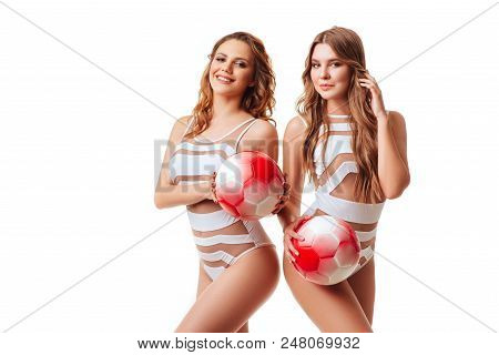 Pretty Bikini Models Holding Red Balls In Studio On Red Background