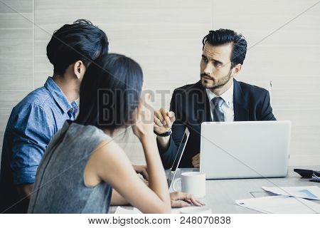 Young Business People Working Together With Serious Emotion. Business People Takling In Modern Offic