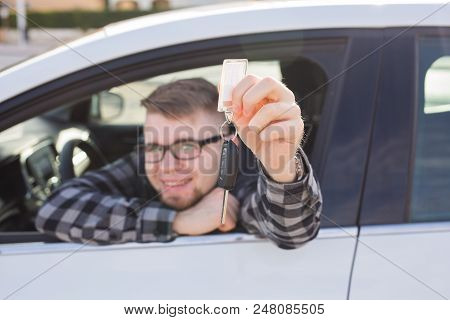Young Man Sitting In Car Holding Car Keys.