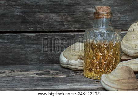 Chaga (shelf Fungus) Mushroom Medicinal Tincture On Wooden Background. Naturopathy. Alternative Medi
