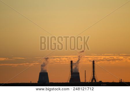 Sunset Over The City. Chp Pipes, Power Station. Industrial Landscape. Bright Sunset Over The Horizon