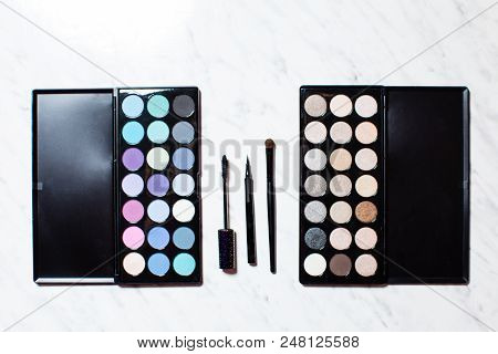 Top View Of The Box With Different Shades Of Eyeshadows That Are Located On The Sides And The Brushe