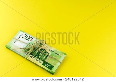 A Bundle Of Money. Russian Cash. A Bundle Tied With A Rope. Denominations In 200 Rubles. On A Yellow