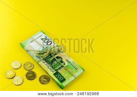 A Bundle Of Money. Russian Cash And A Few Coins. A Bundle Tied With A Rope. Denominations In 200 Rub
