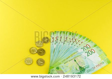 Russian Cash And A Few Coins. Denominations In 200 Rubles. On A Yellow Background