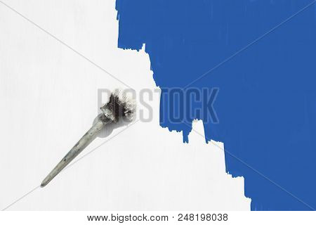 Paint Brush In White Paint On A Wooden Background Is Painted In White And Half In Blue. Flat Lay, To