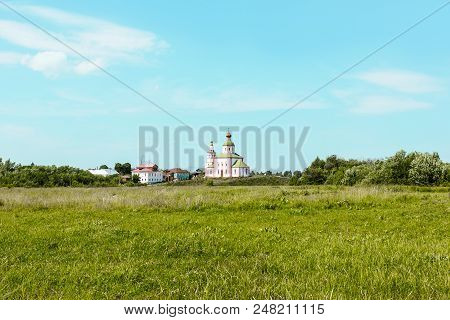 Suzdal Landscape. Green Field And The Old Orthodox Church Of Elijah The Prophet On Ivanova Mountain.