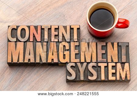 content management system - word abstract in vintage letterpress wood type blocks with a cup of coffee