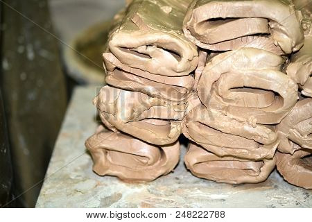 Wet White Clay Closeup. Abstract Pieces Of Wet Clay On The Table. Sculptor Sculpts Pots Products Fro