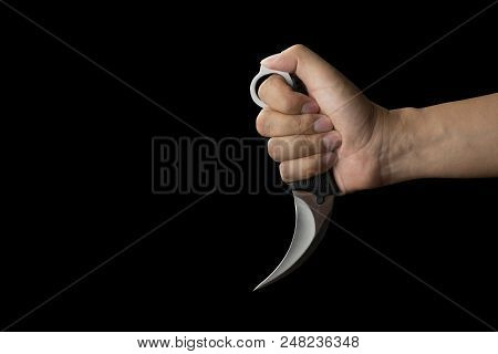 Close Up Of Hand Holding A Karambit Knife, Isolated On Black Background With Clipping Path