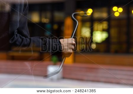 Burglar With A Crowbar On The Background Of The Shop Window.