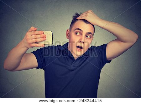 Portrait Shocked Man Feeling Head, Surprised He Is Losing Hair Isolated On Gray Background. Negative