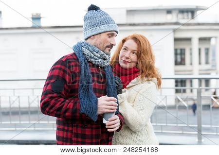 Embarrassed Guy With Coffee Cup In Hand. Sweet Aged Couple Meet On Street. Woman Pleased Guy About C