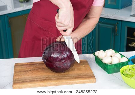 Cook Cutting Red Cabbage With White Knife. Handsome Man's Hand Cut Red Cabbage. Red Cabbage Cut By K