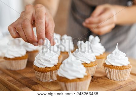 Confectioner Woman Decorates Traditional Capcakes And Muffins With Marshmallow Slices.