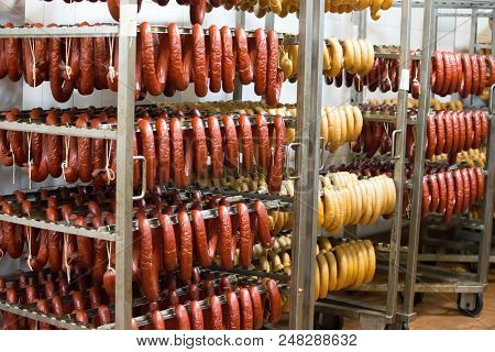 Sausage Workshop.stick Of Sausage Are Smoked On The Background Of The Meat Factory