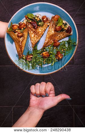 There Is A Blue Plate Full Of Folded Pancakes With Vegetarian Fillings Consisting Of Mushrooms And S